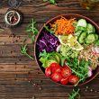A colorful plate of healthy food including fresh vegetables, grilled chicken, brown rice, and a glass of lemon water, representing a balanced diet in a weight management program.